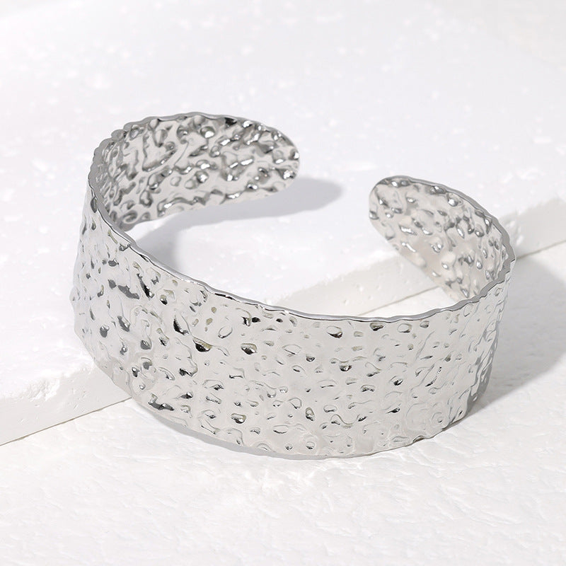 Bracciale da donna in acciaio inossidabile con texture a martellatura irregolare, finitura lucida e design a fascia larga