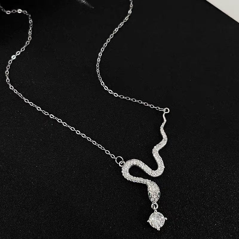 Collar con colgante geométrico minimalista en forma de serpiente de tono frío en acero de titanio con incrustaciones de pedrería y acabado chapado