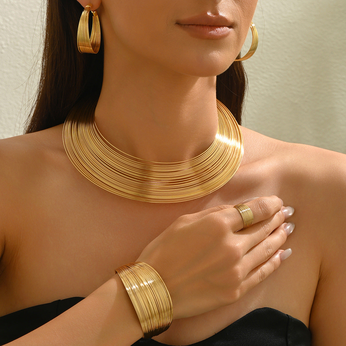Conjunto de collar de metal multicapa con diseño de líneas geométricas, pulsera ajustable y pendientes para mujer