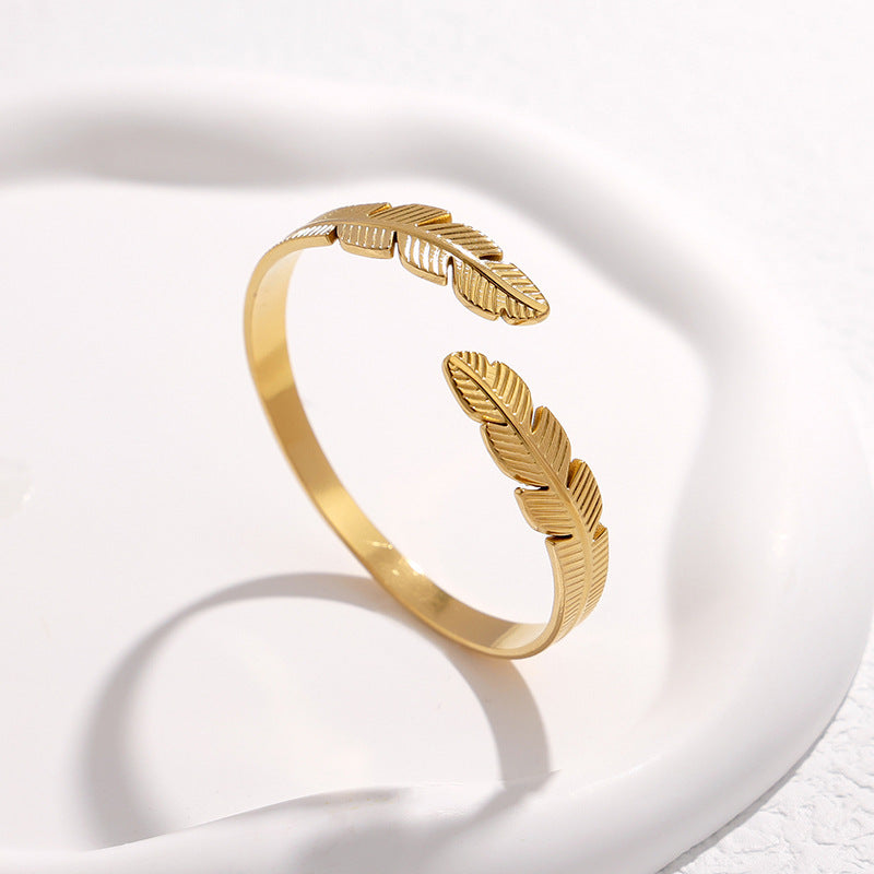 Bracciale a fascia in acciaio al titanio a forma di piuma, minimalista, da donna, con finitura placcata e design aperto regolabile