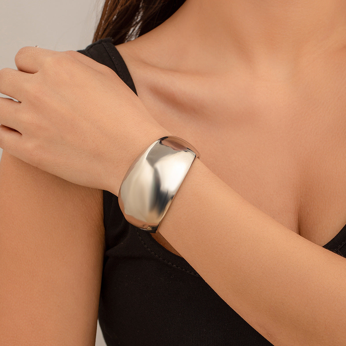 Bracciale rigido da donna in metallo audace con design geometrico, superficie lucida e finitura placcata