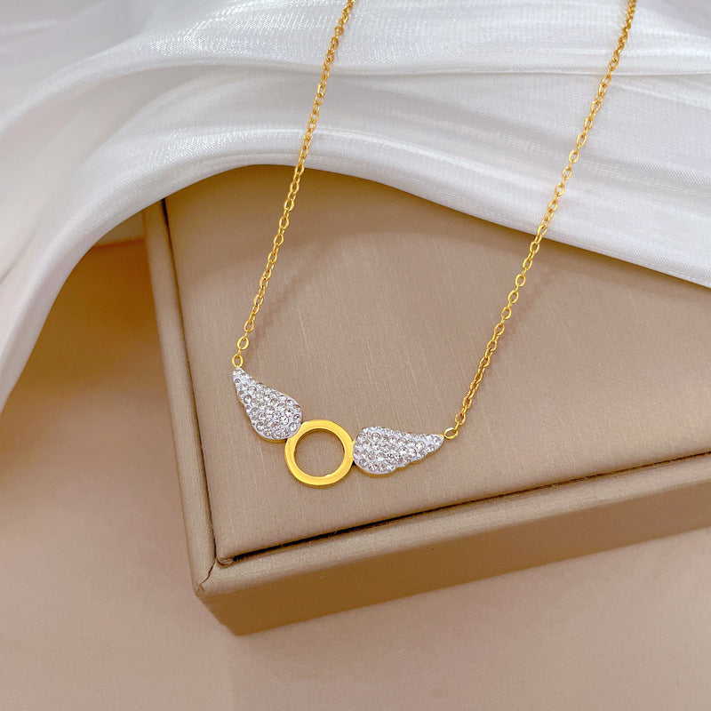 Collana pendente con ali geometriche in stile cartone animato da donna in acciaio al titanio con placcatura in oro e intarsio di strass