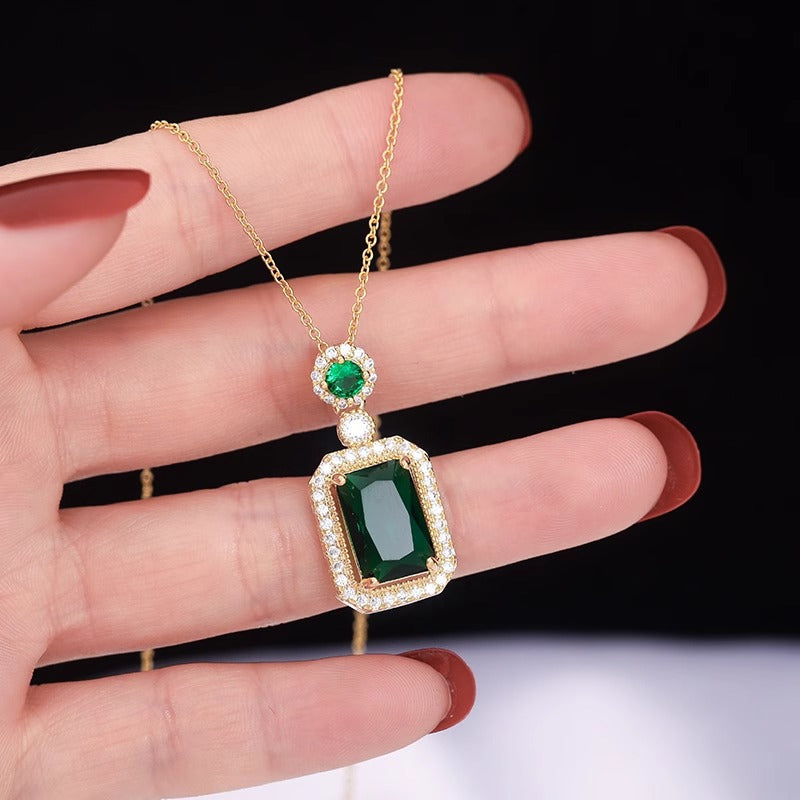 Collana con pendente geometrico di ispirazione vintage in acciaio al titanio con intarsio in rame placcato oro e inserti in cristallo verde su catena a maglie ovali