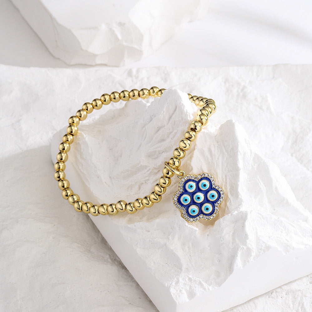 Bracciale geometrico in rame stile INS con placcatura in oro 18K, intarsio di strass e dettaglio occhio blu smaltato