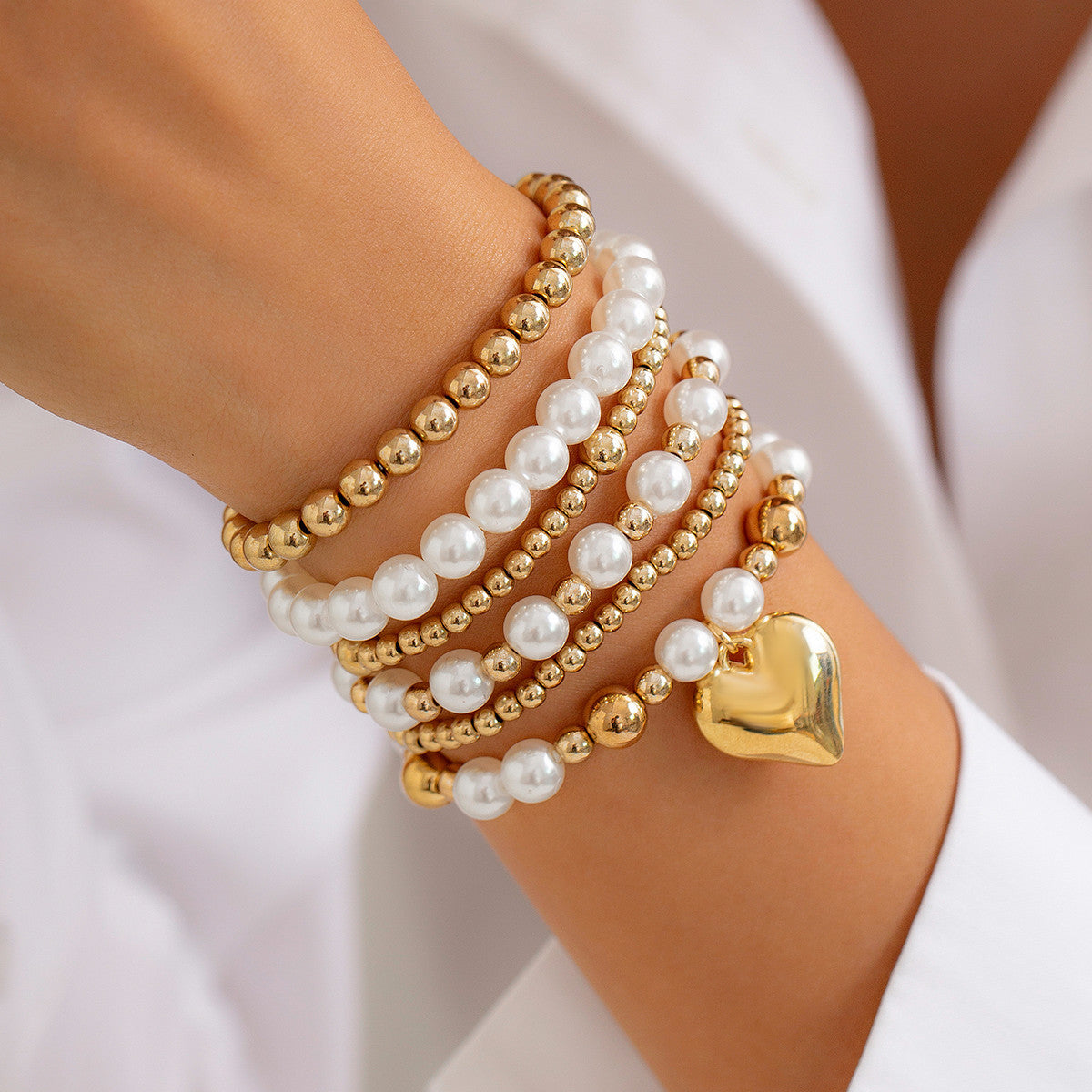 Pulsera elástica minimalista para mujer con perla de imitación en forma de corazón y acabado chapado, ideal para combinar con otras joyas