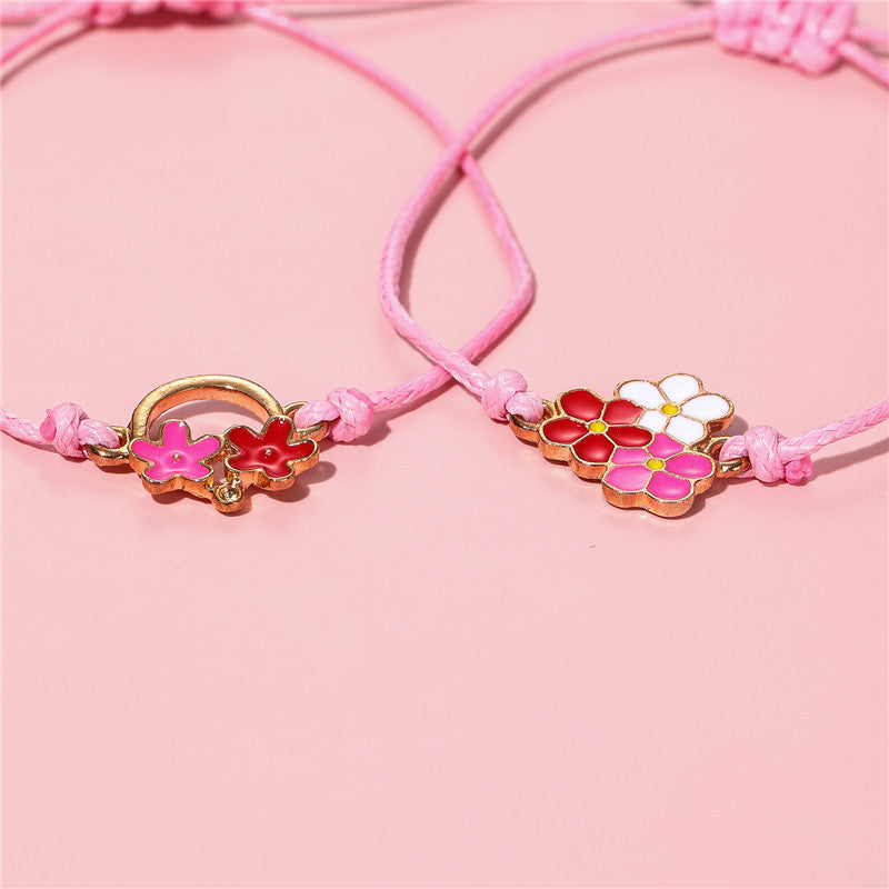 Pulsera infantil de cuerda trenzada con motivo floral y acabado esmaltado en metal de aleación