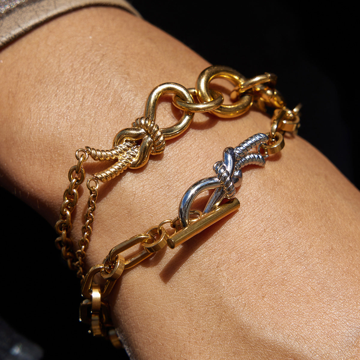 Bracciale in acciaio al titanio con nodo geometrico minimalista e finitura placcata da donna