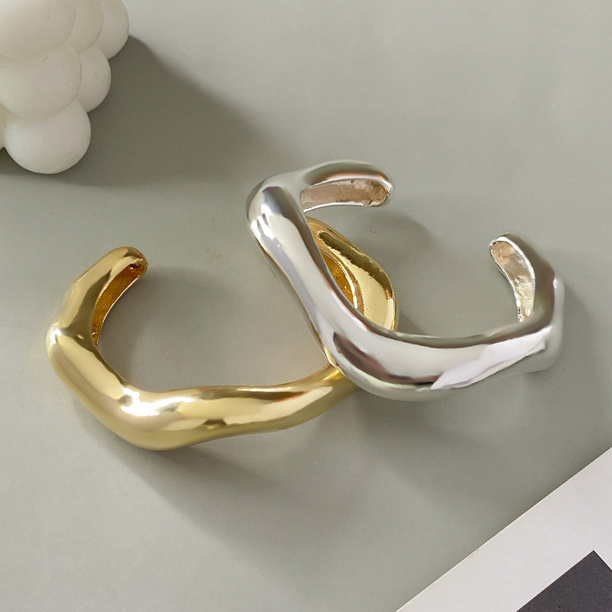 Bracciale rigido da donna in metallo audace con design geometrico, superficie lucida e finitura placcata
