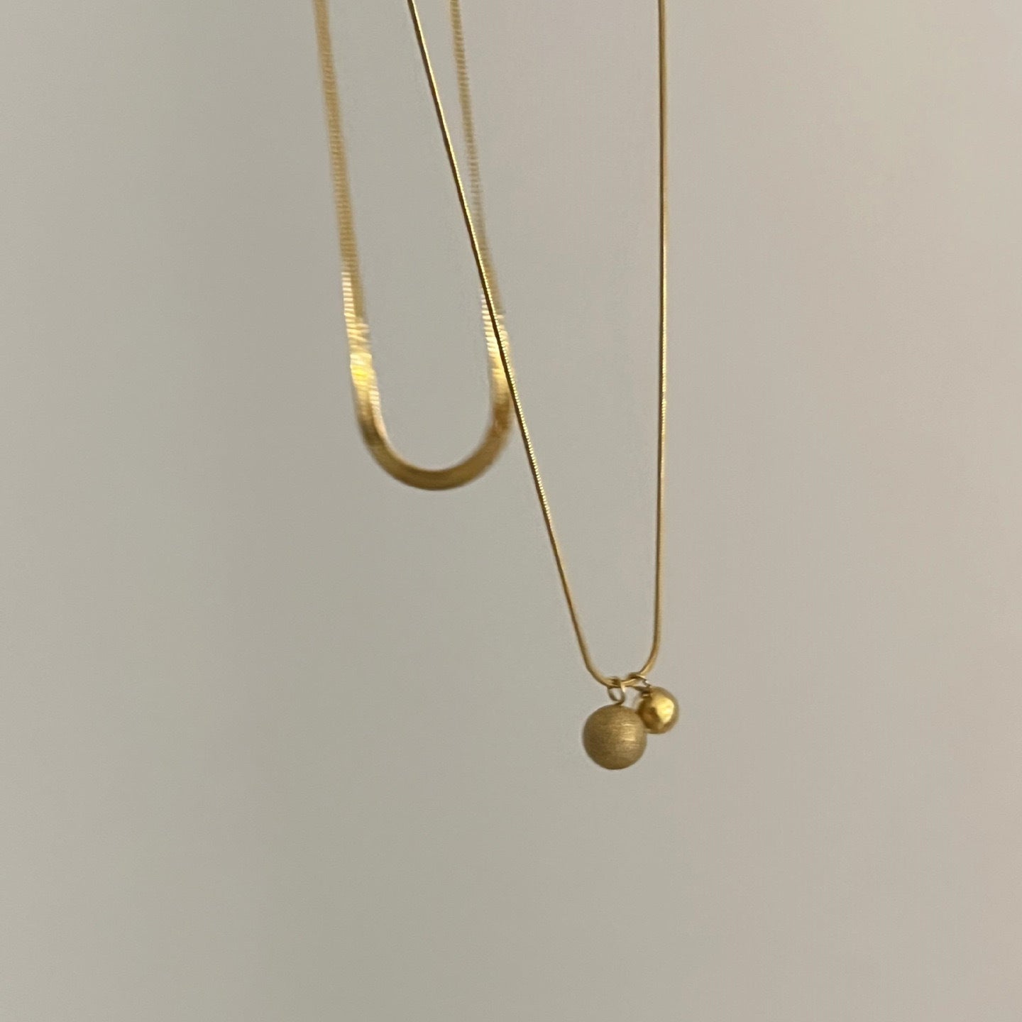 Collana a catena a serpente a doppio strato in acciaio al titanio minimalista da donna con pendenti sferici piccoli e grandi e perline portafortuna