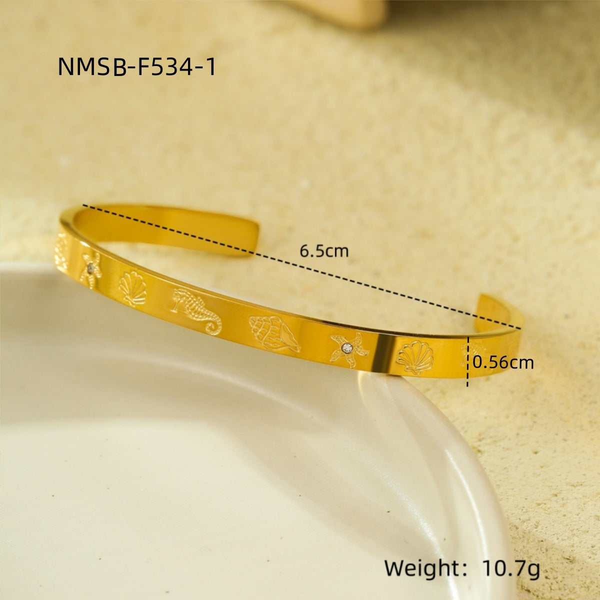 Brazalete abierto de acero de titanio con diseño geométrico, inspirado en el océano, con incrustaciones de pedrería y acabado chapado