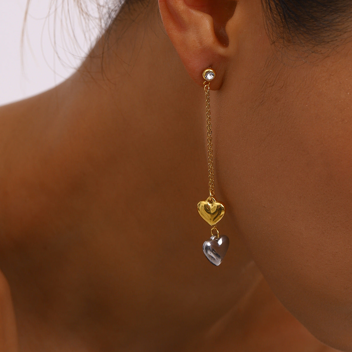 Aretes colgantes elegantes de acero inoxidable con forma de corazón y acabado chapado para mujer