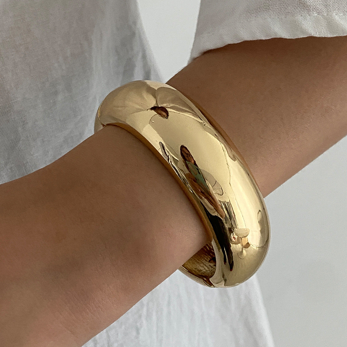 Pulsera geométrica en contraste rojo vivo con acabado pulido y superficie galvanizada para mujer