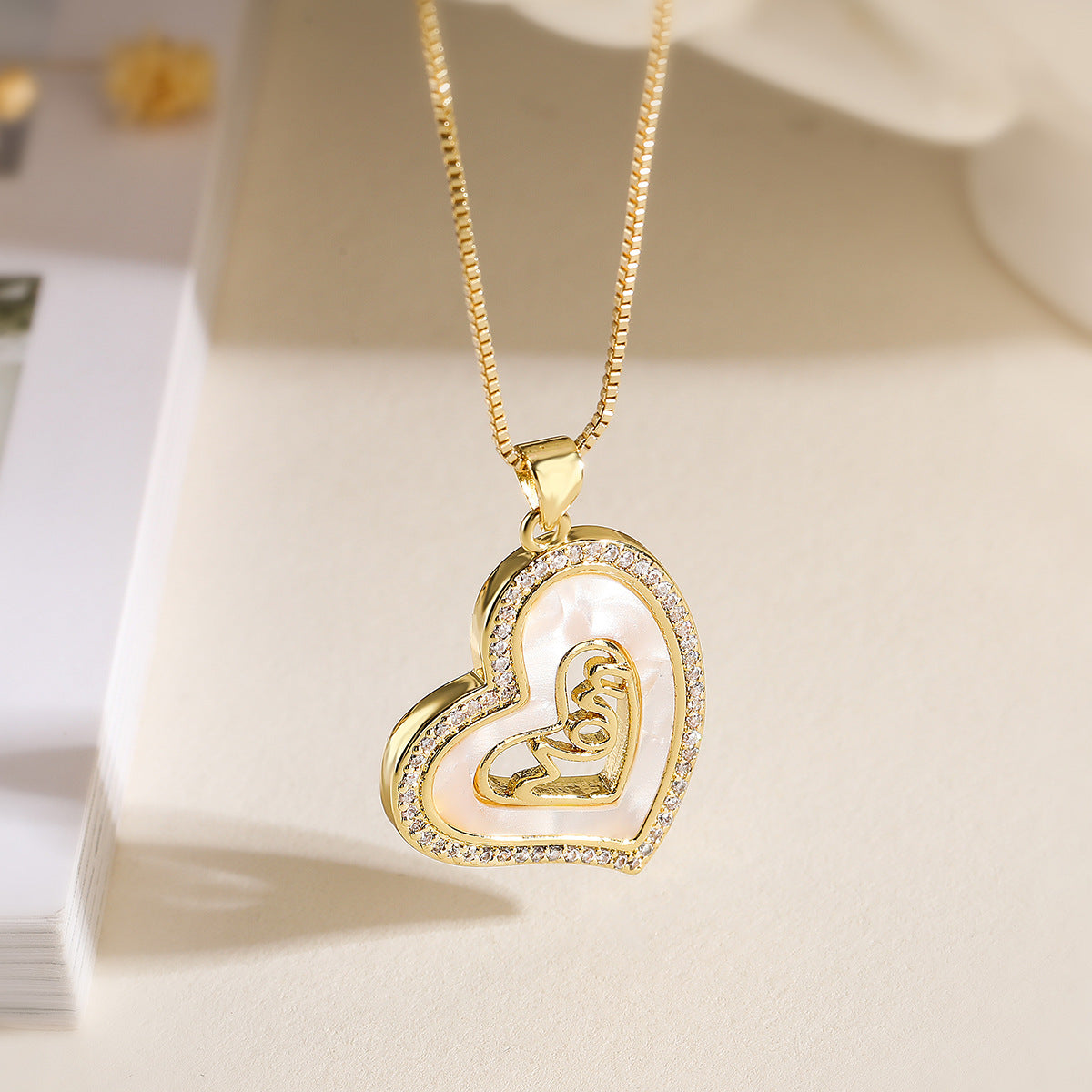 Collana Pendente Minimalista Geometrica MAMMA da Donna con Base in Rame Placcato in Oro Vero e Intarsio di Zirconi a Forma di Conchiglia