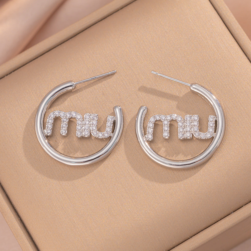 Orecchini a perno Saturno minimalisti color oro in ottone con zirconi per donna