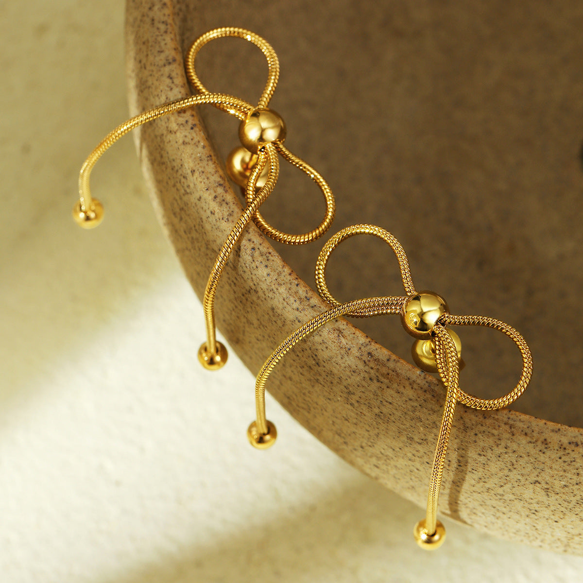 Orecchini da donna in acciaio inossidabile a forma di fiocco, placcati in oro 18 carati e rifiniti in acciaio al titanio, alla moda