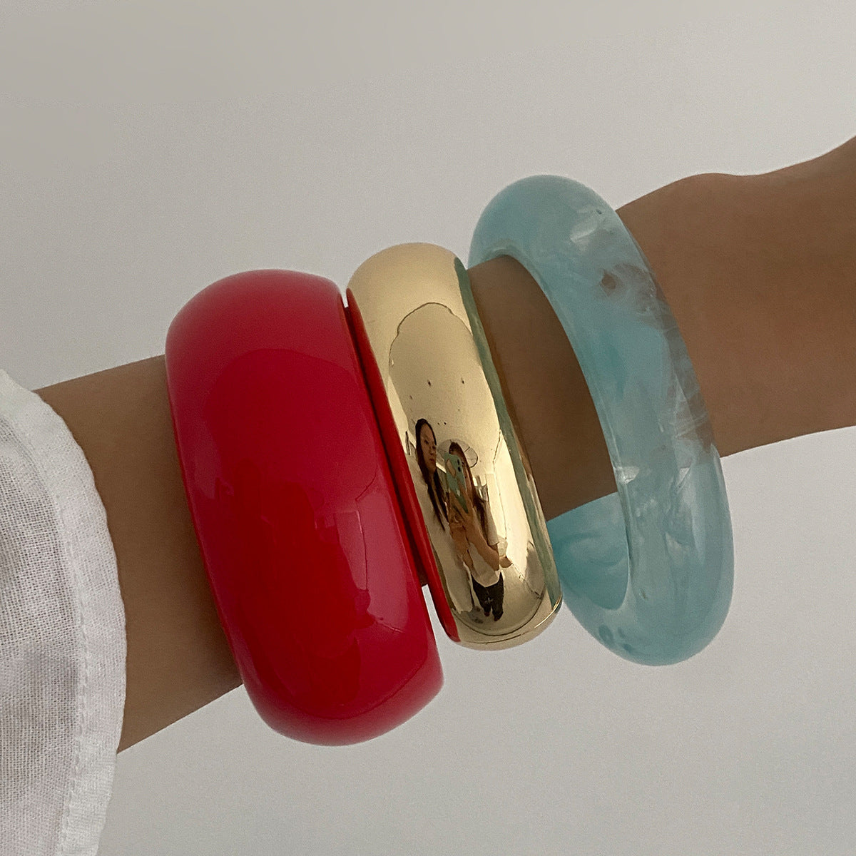 Pulsera geométrica en contraste rojo vivo con acabado pulido y superficie galvanizada para mujer