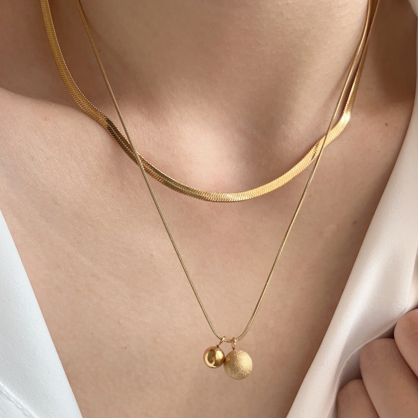 Collana a catena a serpente a doppio strato in acciaio al titanio minimalista da donna con pendenti sferici piccoli e grandi e perline portafortuna