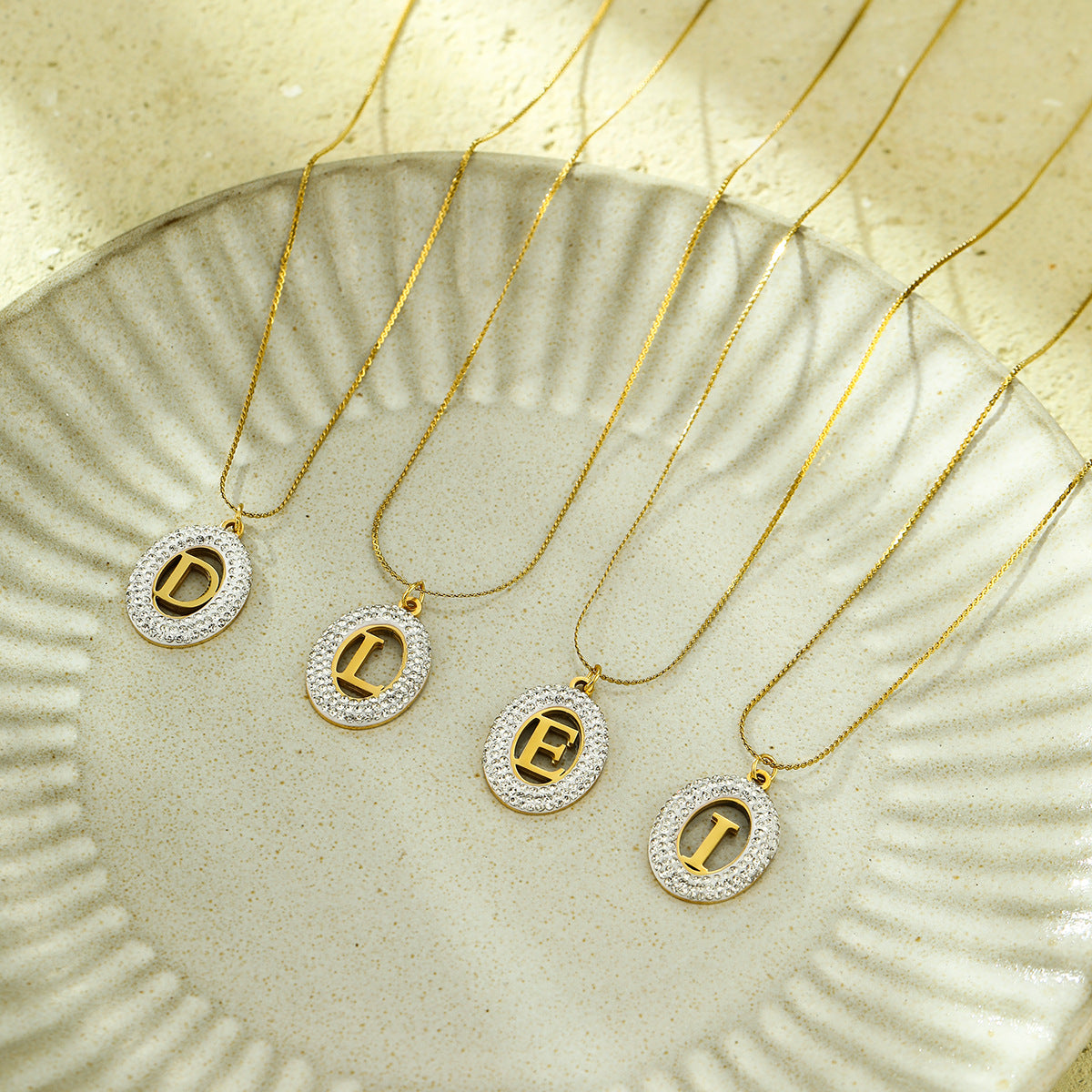 Collana da donna alla moda con ciondolo ovale in acciaio inossidabile con intarsio in zircone e lettera traforata