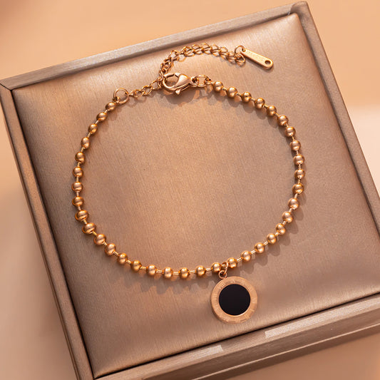 Pulsera minimalista geométrica redonda de acero de titanio para mujer con baño de oro rosa de 18 quilates y acento de letra