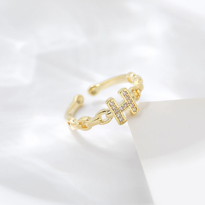 Anello minimalista con lettera H in ottone placcato oro con dettagli in strass e fascia aperta regolabile
