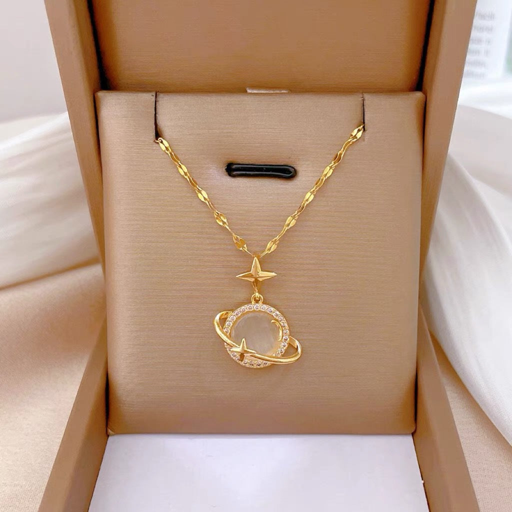 Collana con Ciondolo a Pianeta Minimalista in Acciaio al Titanio con Occhio di Gatto in Rame Placcato Oro e Accenti di Zirconi su Catena a O per Donna