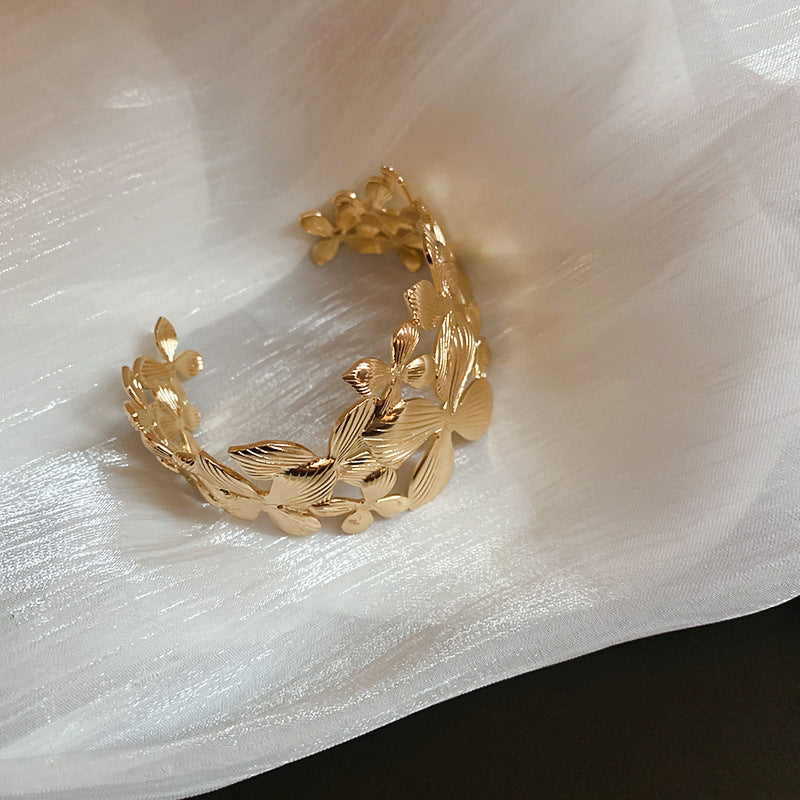 Elegante pulsera de banda ancha calada con forma de flor para mujer con acabado metálico chapado, estilo de oficina a la moda