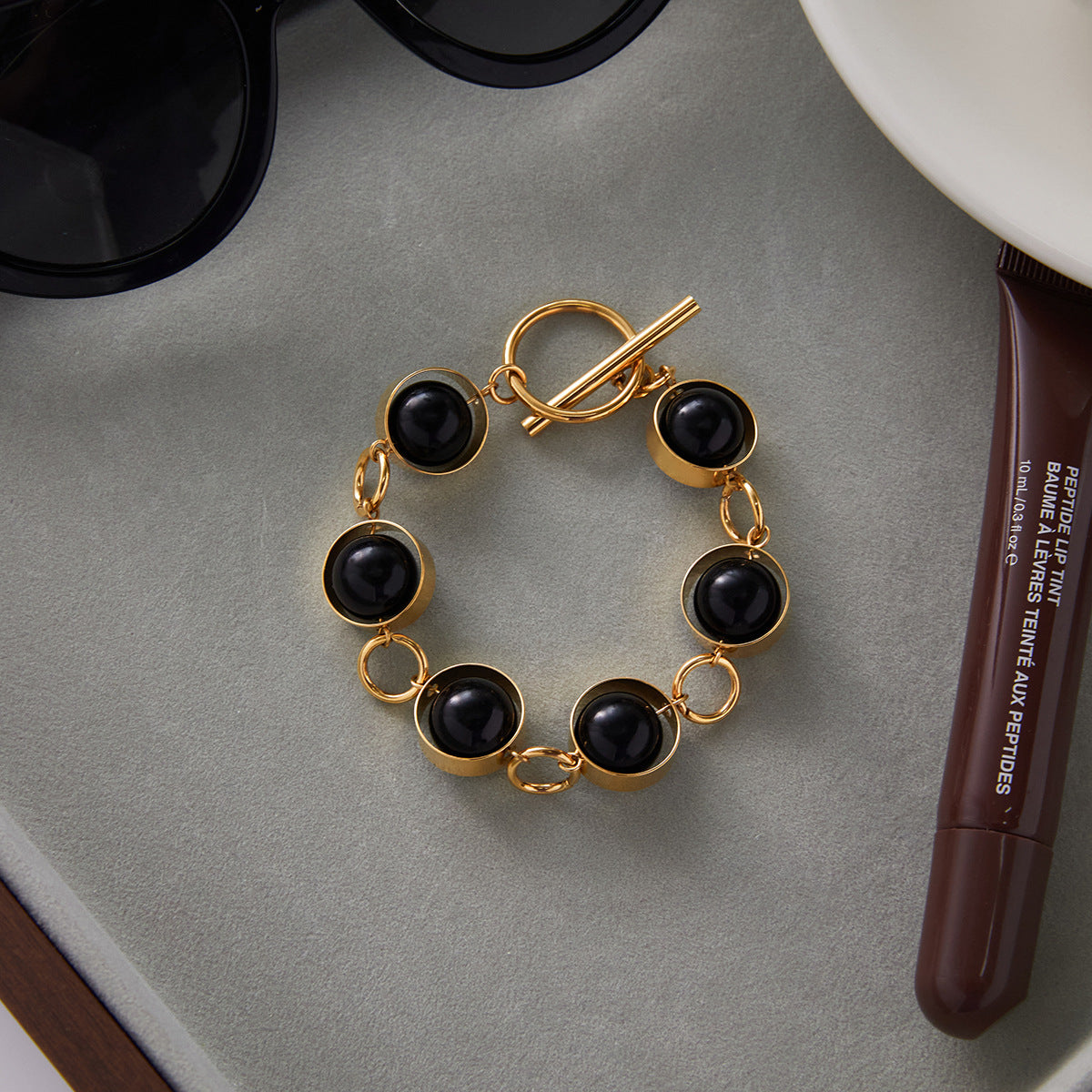 Bracciale minimalista geometrico girevole con chiusura a T in perline di vetro nero e acciaio al titanio con finitura placcata