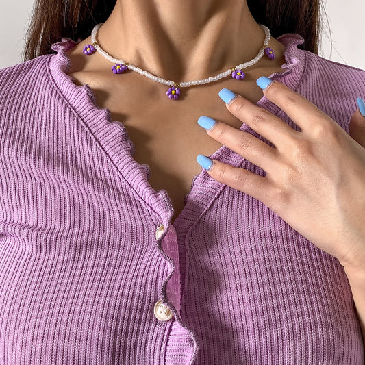 Collana pendente margherita minimalista con dettaglio nappa da donna, con accenti in resina e perline, design floreale rotondo su catena a sfere