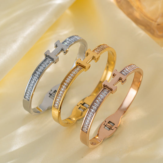 Bracciale da donna a manetta con lettera H, strass, in acciaio al titanio placcato oro 18 carati
