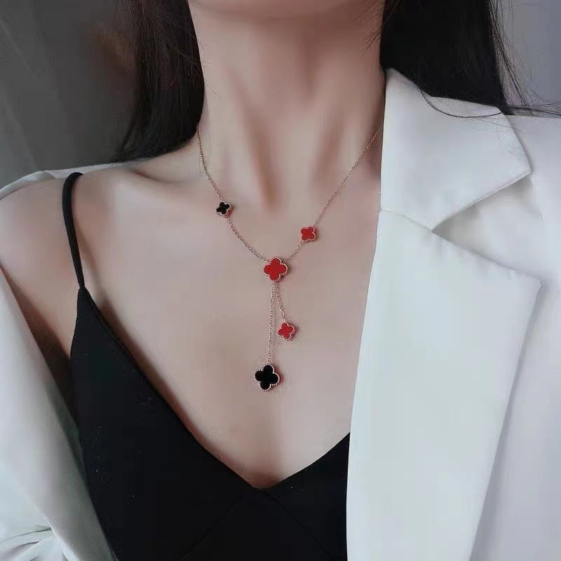 Collana con ciondolo a trifoglio minimalista in acciaio al titanio con placcatura in oro e dettaglio a nappa su catena a O