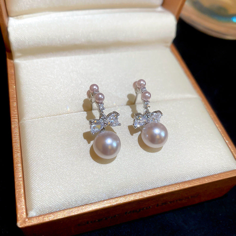 Pendientes de botón con forma de lazo y efecto perla de lujo con incrustaciones de circonita para mujer, poste de acero inoxidable, accesorio de moda minimalista