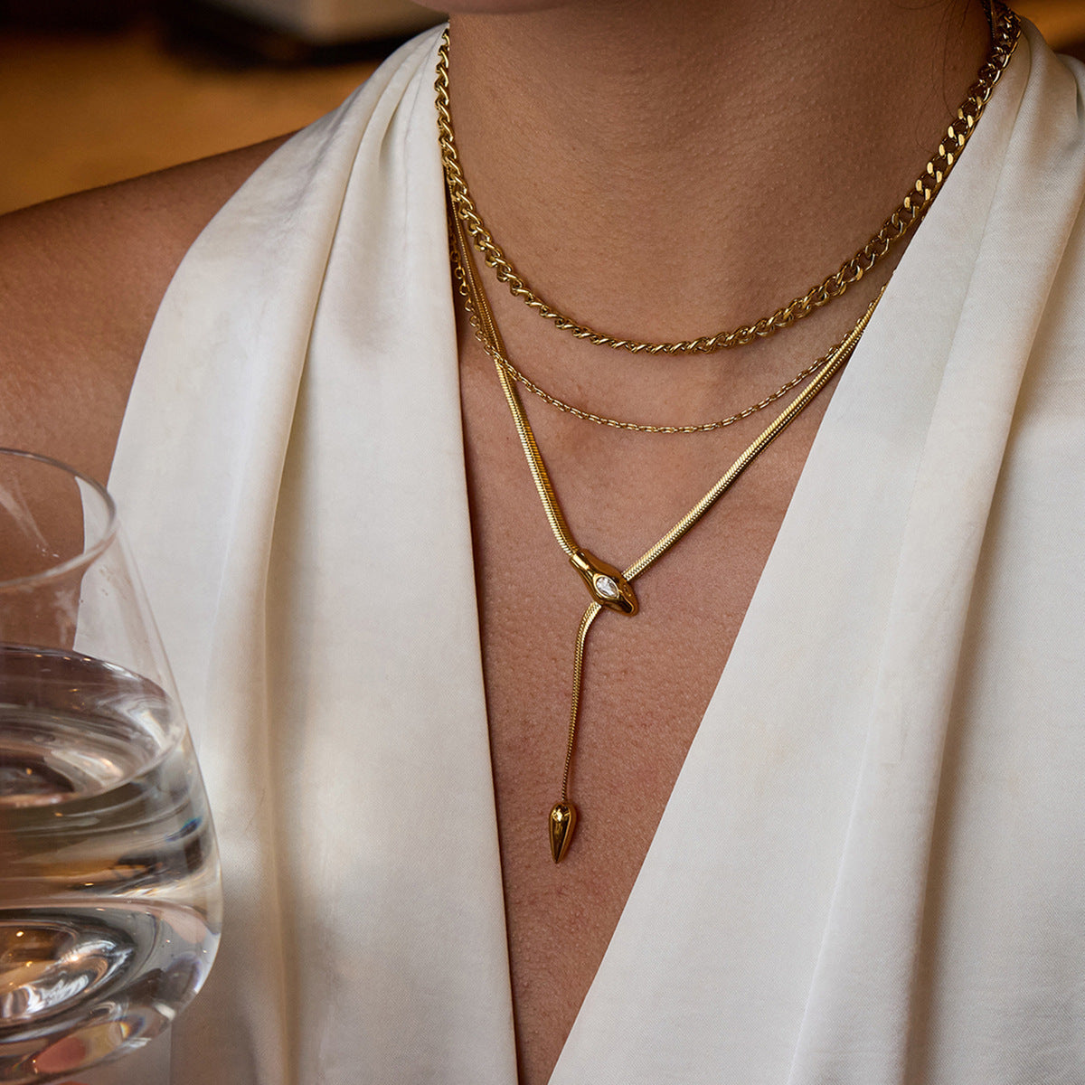 Collana con ciondolo a serpente geometrico in acciaio al titanio con intarsio di strass e finitura placcata per donna