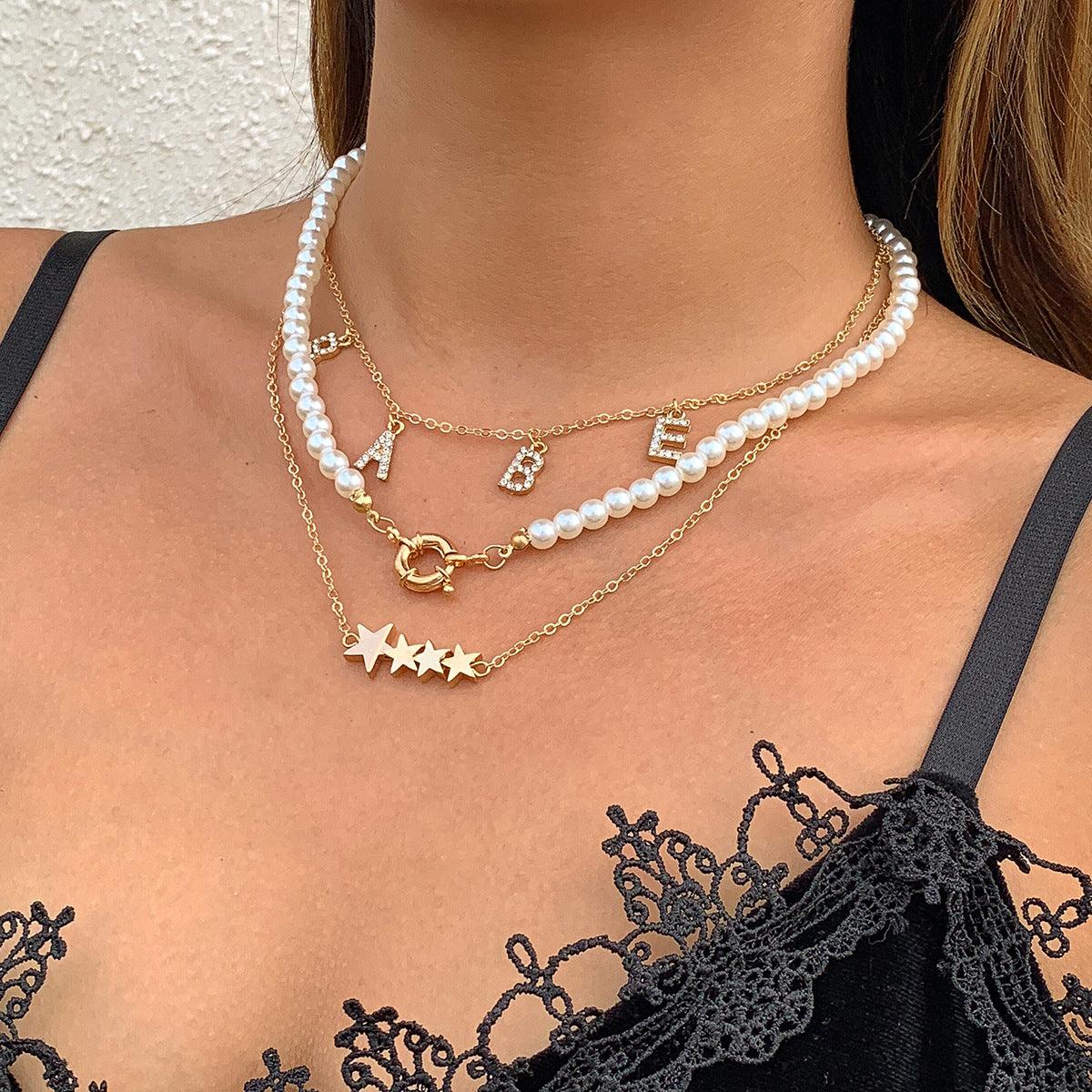 Collana da donna personalizzata con nappa a forma di stella geometrica, lettera e strass, perle sintetiche e catena di perline