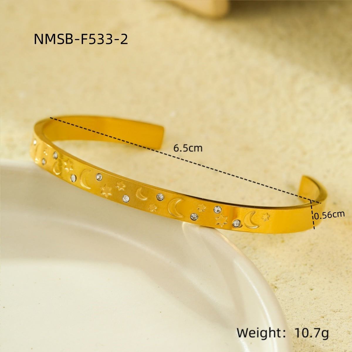 Brazalete abierto de acero de titanio con diseño geométrico, inspirado en el océano, con incrustaciones de pedrería y acabado chapado