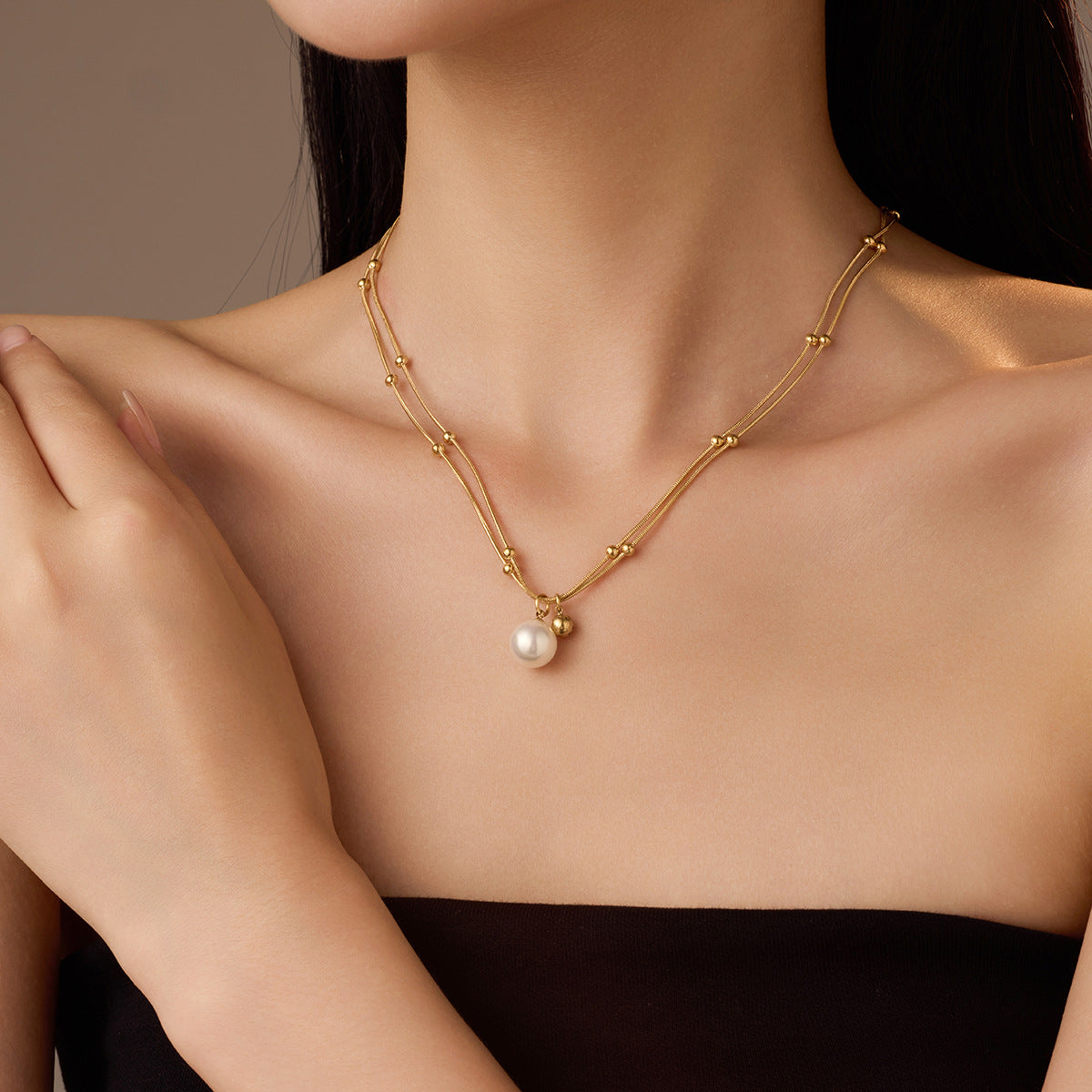 Collana minimalista con perle, doppia catena in acciaio al titanio e design con clavicola placcata in oro 18 carati