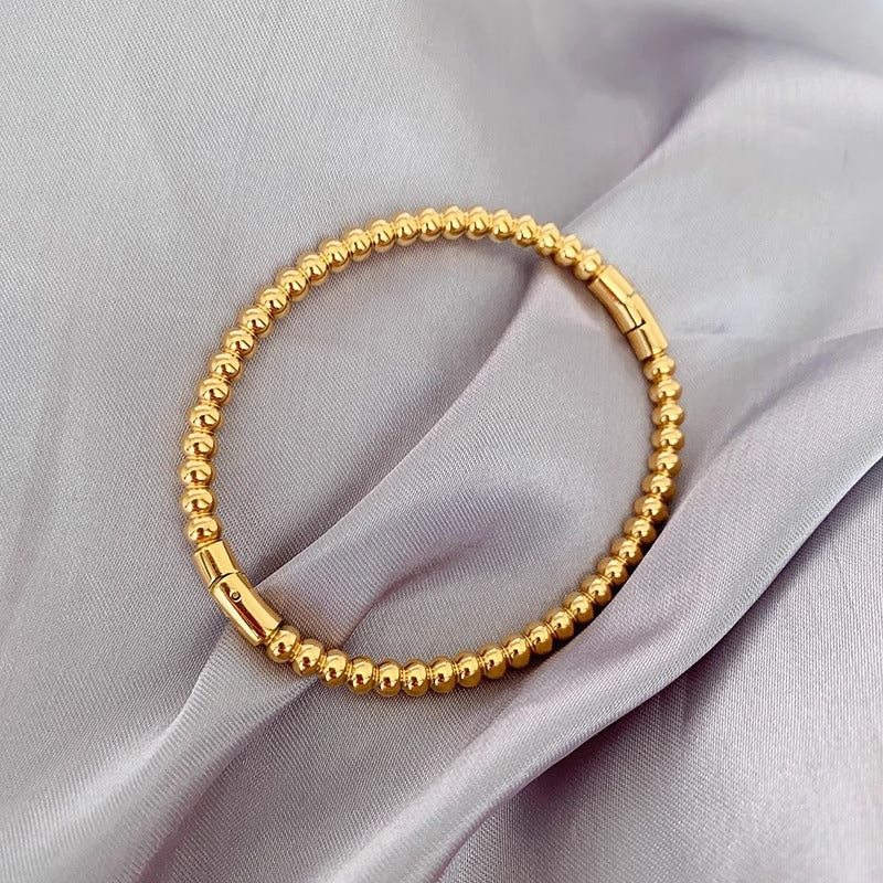 Bracciale minimalista da donna in acciaio al titanio color oro con perline rotonde lucide