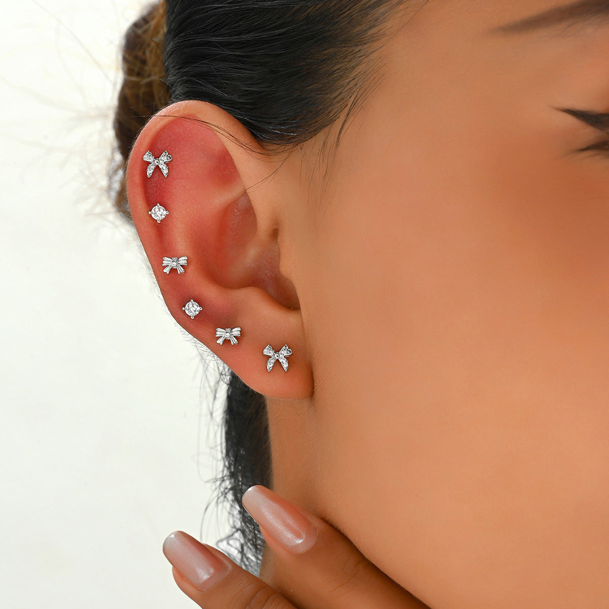 Dulces aretes minimalistas de cobre en forma de moño con incrustaciones de diamantes de imitación para mujer