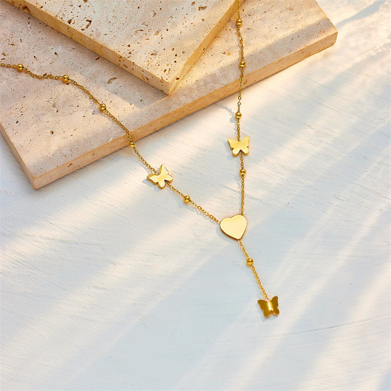 Collar con colgante minimalista de corazón y mariposa con borlas de acero titanio con acabado chapado para mujer