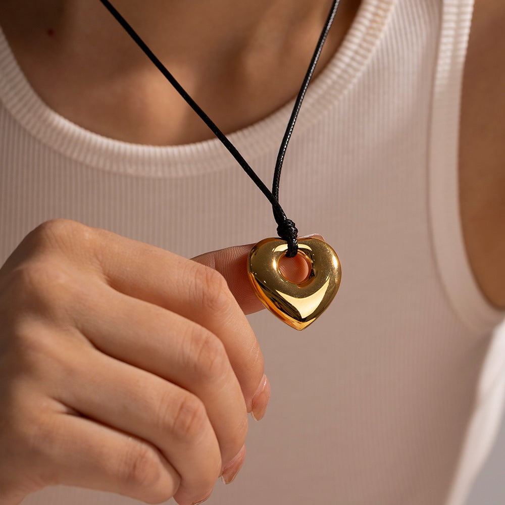 Collar con colgante de corazón hueco minimalista de acero inoxidable con cordón de cera negro y acabado chapado