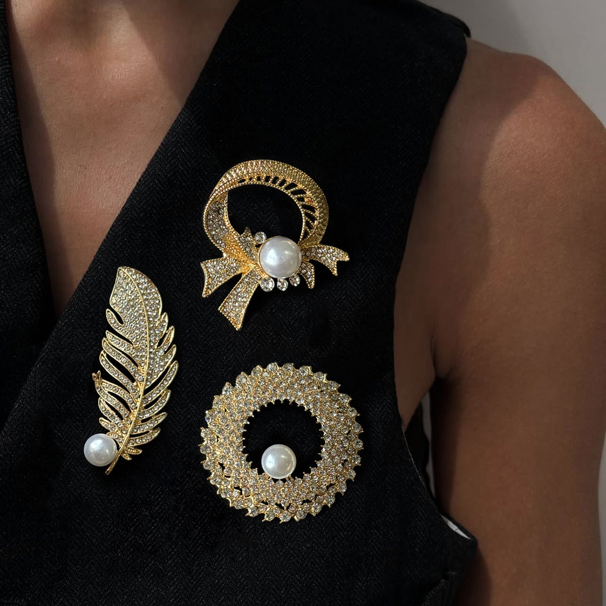 Elegante broche de lujo con incrustaciones de pedrería y detalles de perlas de imitación en base de aleación. Accesorio de moda en forma de pluma para mujer.