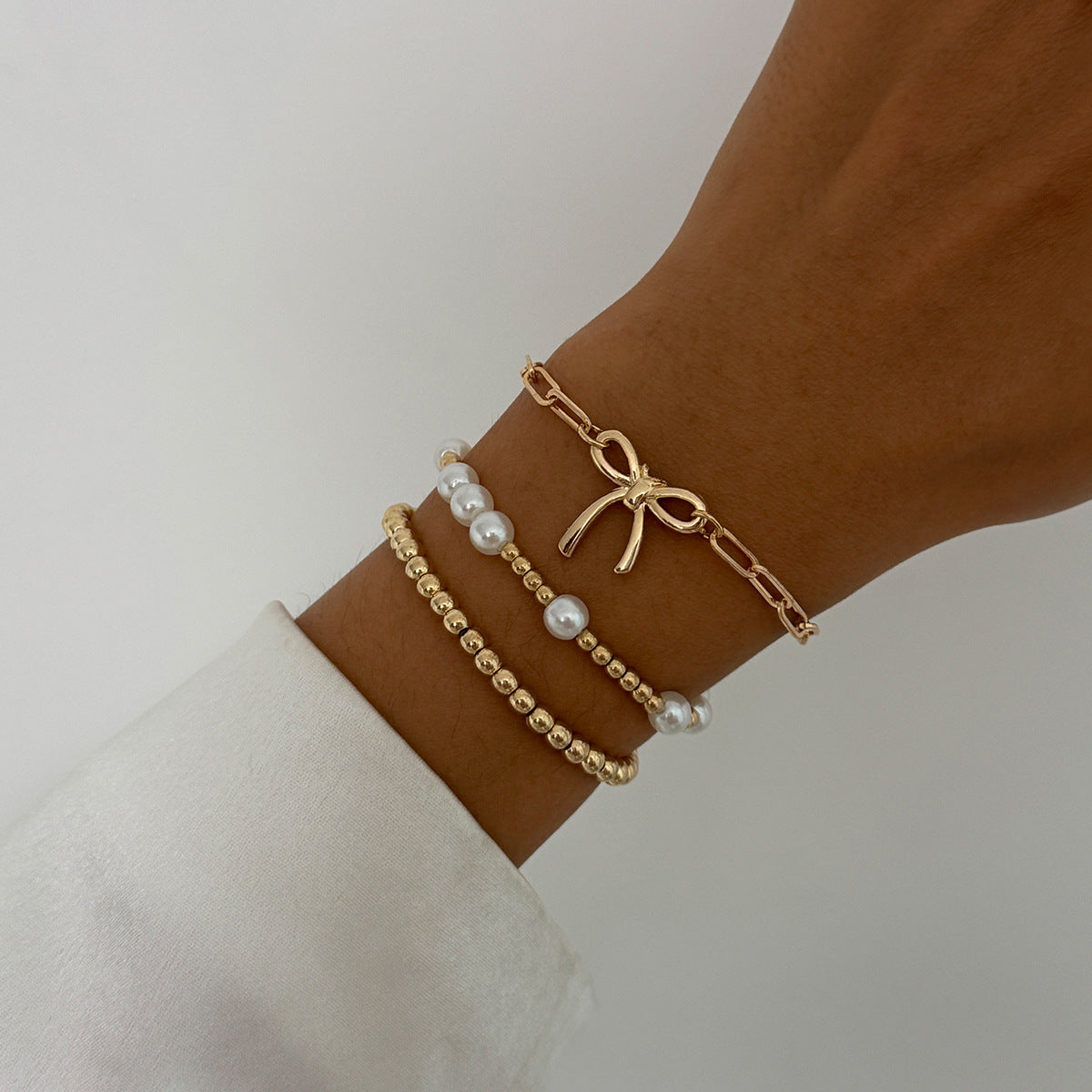 Minimalist Bow Knot and Star-Shaped Pendant Bracelet for Women with Plated Metal and Imitation Pearl Accents