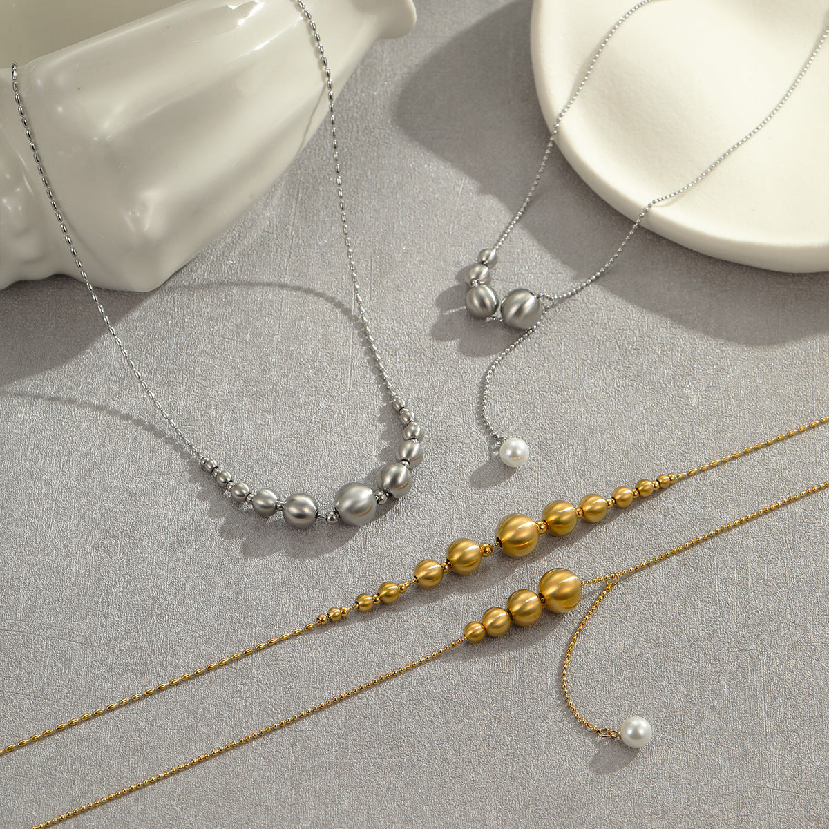 Collana da donna alla moda con perline a occhio di gatto in acciaio al titanio spazzolato con pendente geometrico placcato in oro 18 carati e delicata catena clavicolare