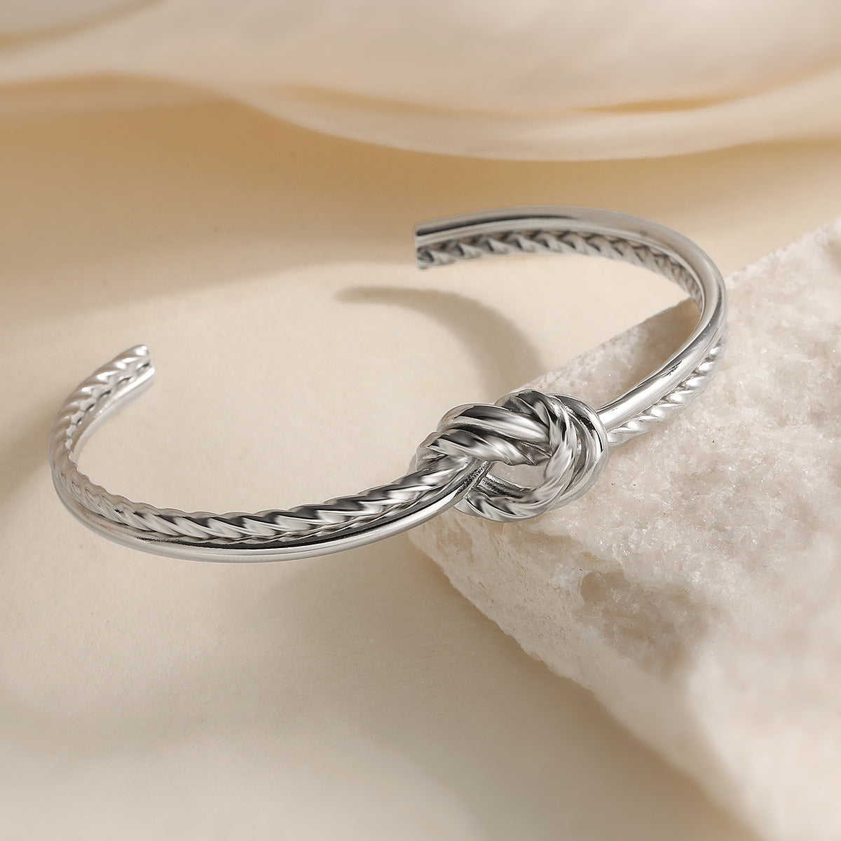 Bracciale minimalista da donna in acciaio inossidabile con apertura a nodo geometrico e finitura placcata