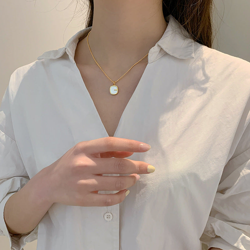 Collana da donna con pendente a G geometrico minimalista in madreperla, catena in acciaio al titanio e finitura placcata