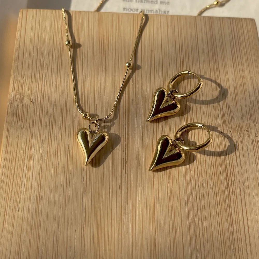 Pendientes minimalistas de corazón de acero inoxidable y titanio de contraste con baño de oro, acabado pulido, accesorio de moda versátil para mujer