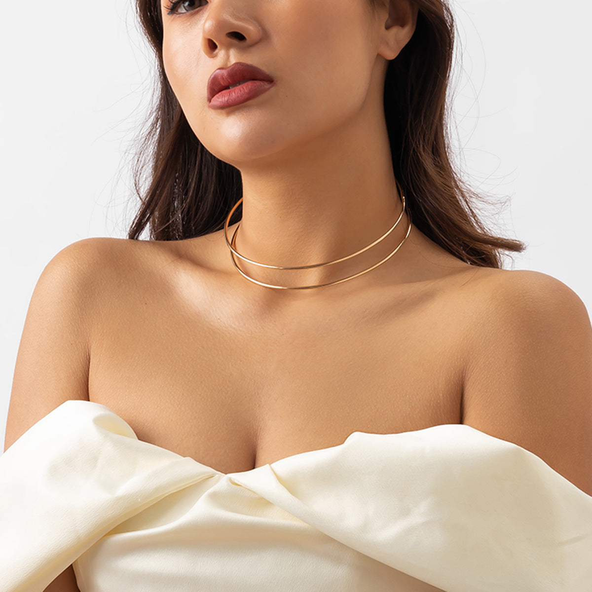 Collana girocollo minimalista in metallo tonalità fredda con contorno di croce geometrica e design aperto per donna