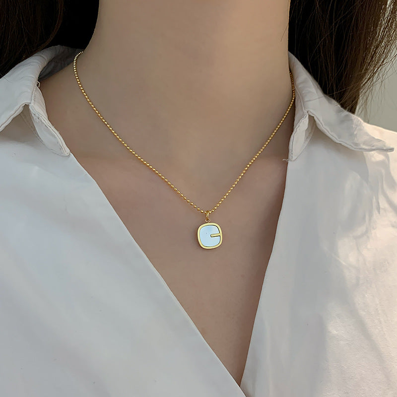 Collana da donna con pendente a G geometrico minimalista in madreperla, catena in acciaio al titanio e finitura placcata