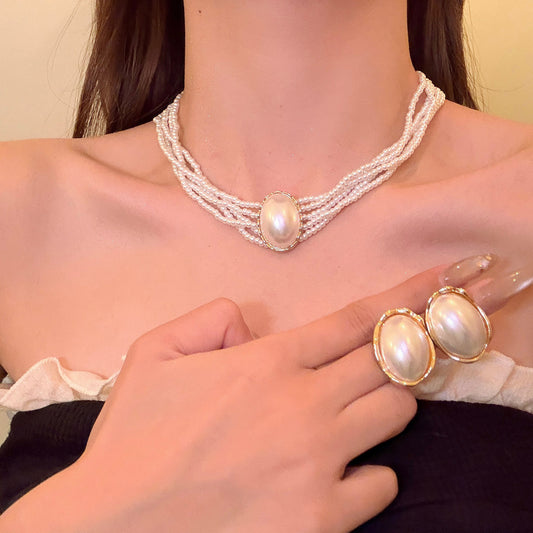 Elegante conjunto de collar y pendientes ovalados de perlas de imitación multicapa de estilo francés para mujer con acabado chapado y diseño de cadena a la altura de la clavícula