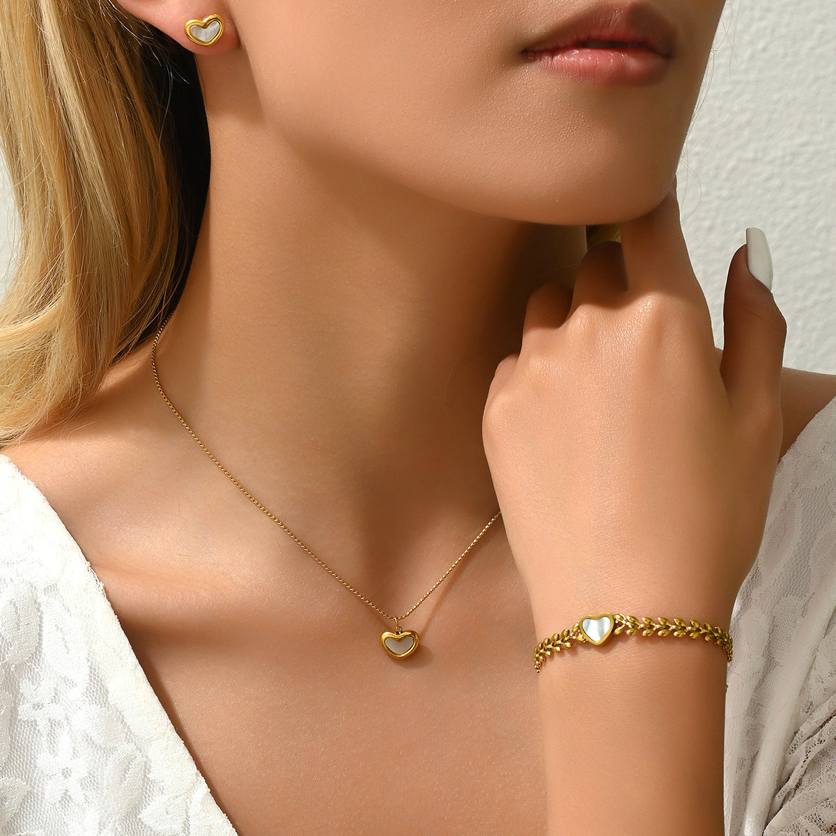 Encantador conjunto de pulsera, collar y pendientes de perlas y nácar en forma de corazón, de cobre con acabado micropavé.