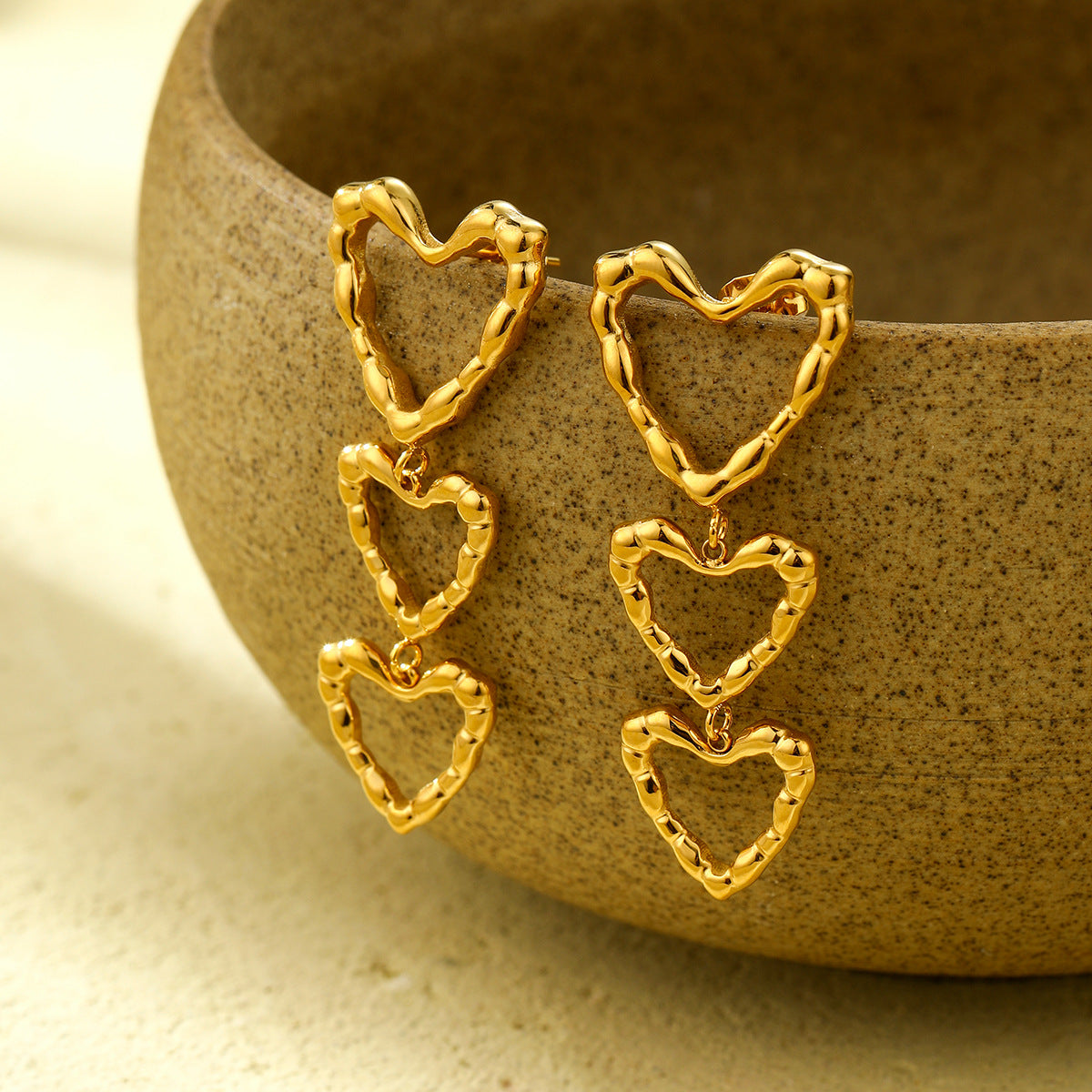 Pendientes de acero inoxidable a la moda con diseño irregular hueco de corazón, detalle de borla y acabado chapado